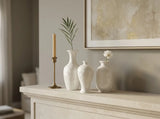 Three crystalline glaze mini vases holding single white flowers and delicate green stems