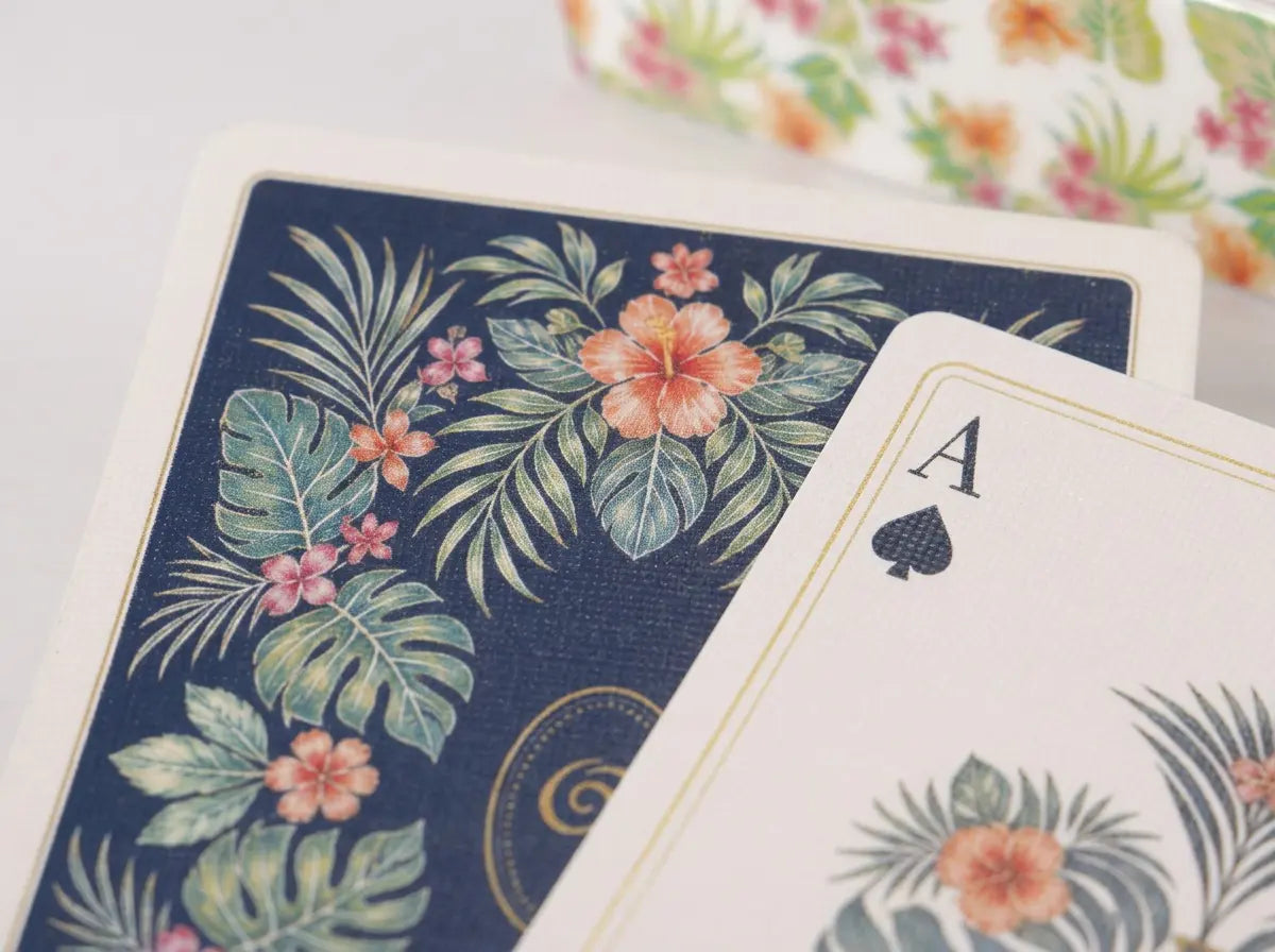 Close-up of the contrasting navy and ivory tropical botanical card backs with fine gold-tone borders
