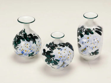 Set of three Wisteria Reverie hand-painted porcelain mini bud vases in varied rounded silhouettes.