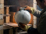 Hand-painted porcelain globe vase with blue floral motif and round shape