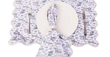 Close-up of embroidered table linen with stitched edges showing thicker structure and premium finish on coasters and napkins