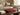 Closed burgundy mahjong case displayed on a coffee table with books and decorative home accents