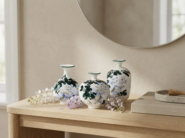 Three hand-thrown porcelain bud vases showing the distinct tall, low round and shouldered forms.