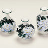 Set of three Wisteria Reverie hand-painted porcelain mini bud vases in varied rounded silhouettes.