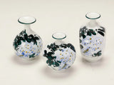 Set of three Wisteria Reverie hand-painted porcelain mini bud vases in varied rounded silhouettes.